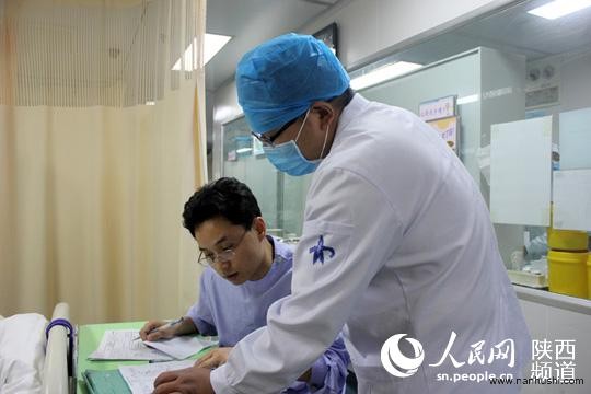 王家鹏护士与医生沟通病人的用药情况。庞铭/摄